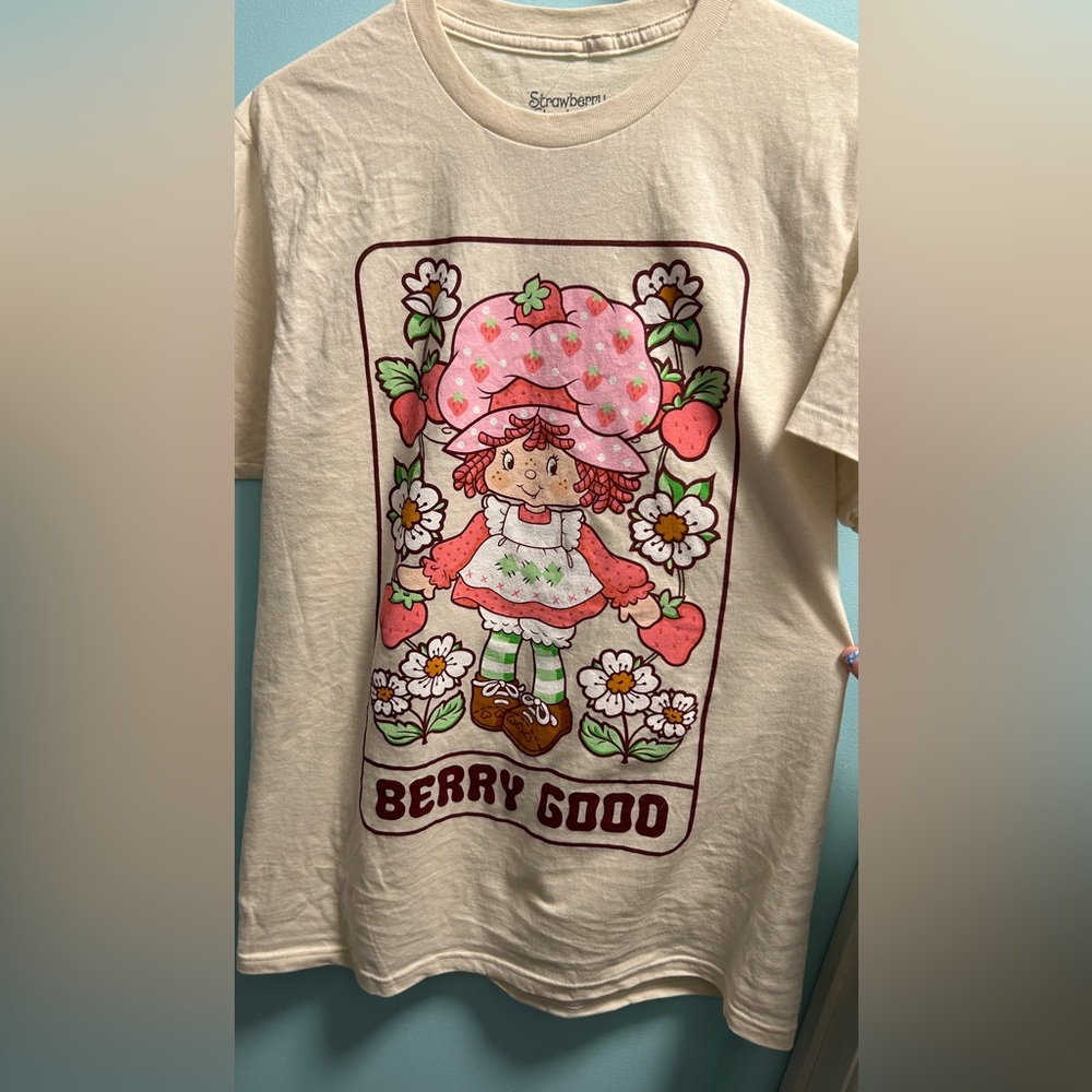 Hot topic, Tan/Creamish color shirt with Strawberry shortcake on the front.